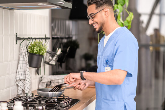 Smiling Young Man Cooking On The Gas Stove