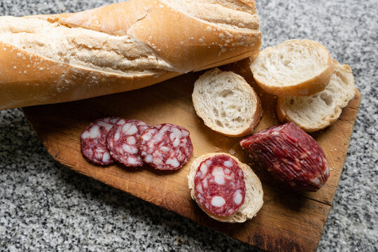 Top view of country salami with bread on a wooden board