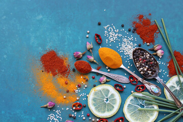 Different types of aromatic herbs and spices on vibrant blue background. Colorful picture of...