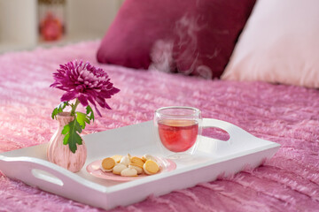 red tea in thermo glass with flowers in modern bedroom