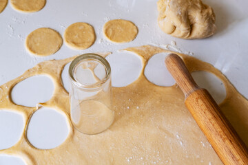 Making homemade dumplings from meat, rolling out the dough with a rolling pin.