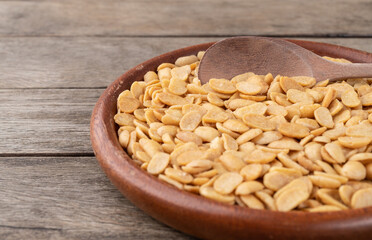Fried soy beans snack in a plate over wooden table with narrow focus