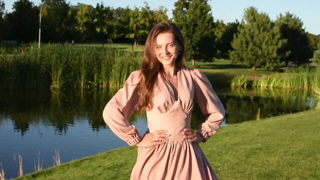 Young smiling woman relaxing outdoors and having a picnic on a blanket on the grass