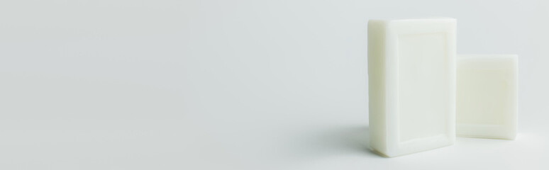 white toilet soap bars on grey background with copy space, banner.