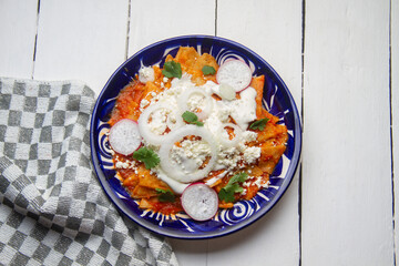 Red chilaquiles with cheese and sour cream. Mexican food