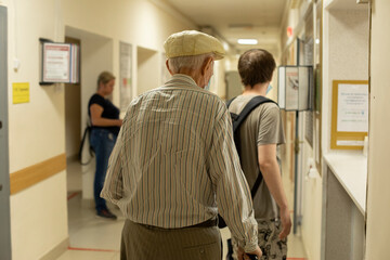 Pensioner in hospital. Grandpa in hallway of medical facility. Elderly person is looking for...