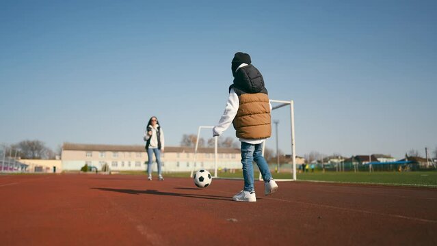 Little boy with a soccer ball at football field. Future football star. Football training concept.
