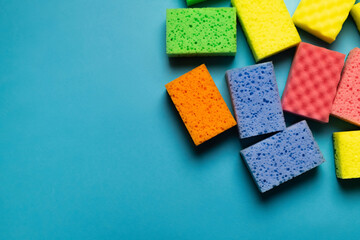 top view of colorful cleansing sponges on blue background.
