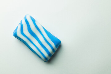 top view of bath soap in blue and white stripes on grey background.