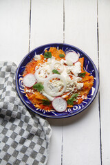 Red chilaquiles with cheese and sour cream. Mexican food