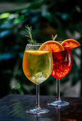 Aperol spritz cocktail garnish with grapefruit and rosemary in front of dark background. Summer...
