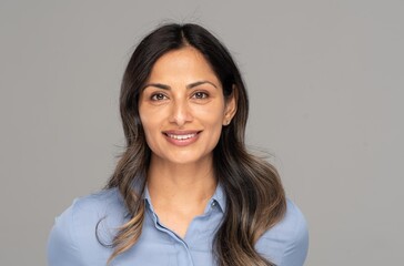 Studio headshot of beautiful Asian Indian woman in blue blouse.