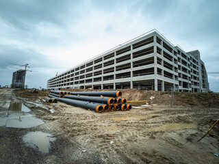 Water pipes for supplying communications lie on the construction site. Next to it is a large...