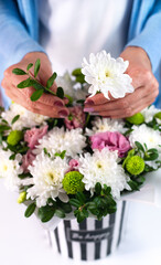 The florist woman makes a beautiful birthday bouquet. Close-up. Selective focus.