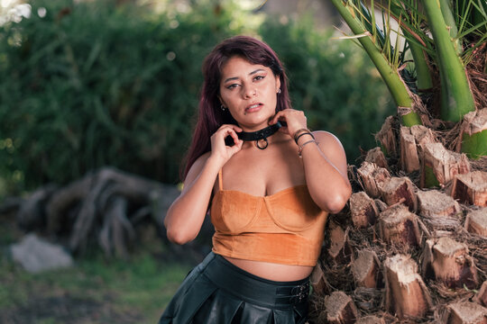 Latin woman in sexy orange tank top with a black leather dress 