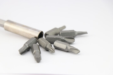 Drill bits of various shapes along with screwdriver head on white background