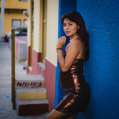 Beautiful Latina on a mexico street against a blue wall 