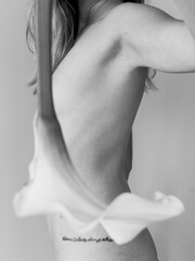 White calla lily covering the naked body of a young girl