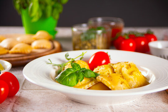 Homemade traditional italian ravioli pasta with basil and tomato cherry vegetables on the table