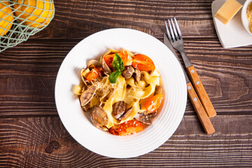 Traditional italian seafood pasta on white plate with clams vongole with tomatoes and basil. Tasty and delisious food.