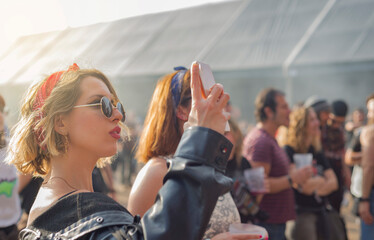 Portrait of a young girl looking at her cell phone at a rock festival
