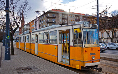 Fototapeta na wymiar Orange tram on the street of Budapest, Hungary