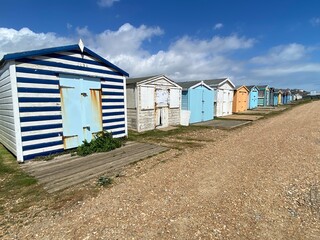 Fototapeta na wymiar bulverhythe beach, West St. Leonards, East Sussex, UK - beautiful shingle pebble beach with beach huts boats 
