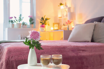 Fototapeta na wymiar two thermo glasses of coffee on white table in pink bedroom