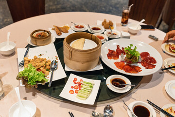 Crispy skin duck with soy sauce, flour sheet, fried tofu on round table in chinese restaurant