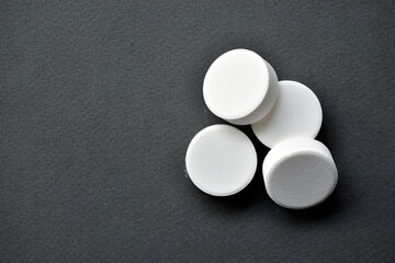 White large round tablets on a gray background. Medicines.