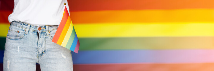 Stylish Woman in blue jeans with the LGBT pride flag sign. Concept of the Pride day, Valentine day, freedom, love. Flat lay, top view, template, overhead