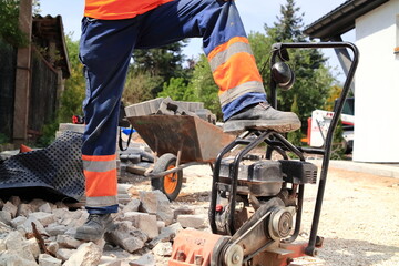 Construction. The foreman at the construction site puts his foot on the compactor.
Budowa. Brygadzista na budowie stawia stopę na zagęszczarce. 