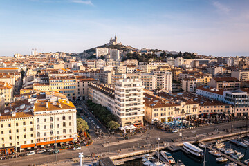 Fototapeta na wymiar Vue aérienne en drone sur le vieux port de Marseille en France avec la ville au loin et la basilique Notre Dame de la Garde (surnommée la bonne mère)