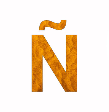 Alphabet letter Ñ - Turmeric powder background