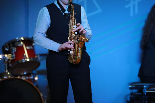 A Musician A Music College Student Playing Solo Saxophone Stands On Stage At The Drums In A Blue Light