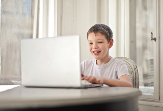 young boy uses a notebook at home