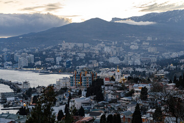 city ​​by the sea on the slope of the mountains in the evening