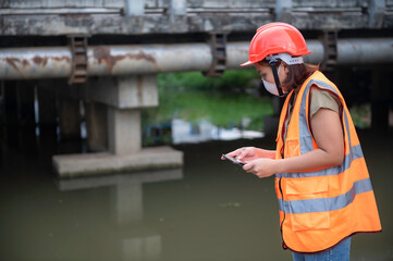 Asian Female engineering working . at sewage treatment plant,Marine biologist analysing water test...