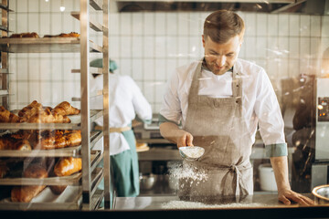 Man baker using flour to prepare dough for baking
