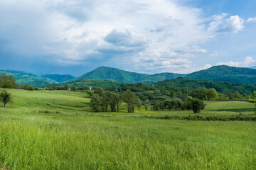 Idyllic landscape with fresh green meadows and mountain tops in the background, in the beautiful surroundings of the Malo Bonjince, Serbia