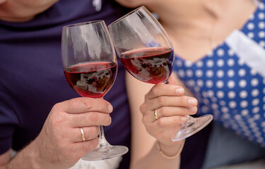 loving couple holding glasses of red wine