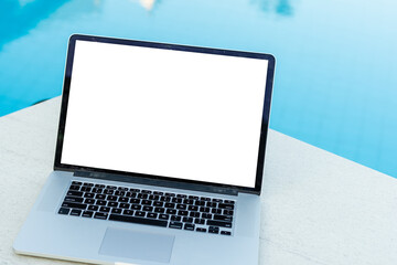 Computer laptop with blank screen near the swimming pool.