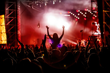 Plakat Men and women with raised hands at a concert event.