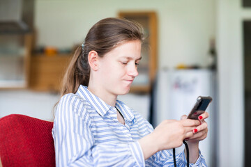 Junge blonde Frau zu Hause konzentriert mit Smartphone