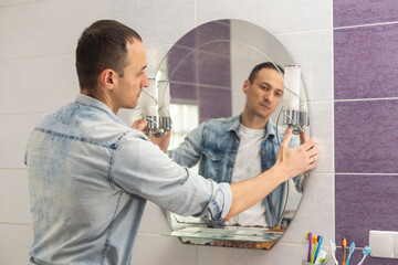 Handyman installing a mirror in bathroom