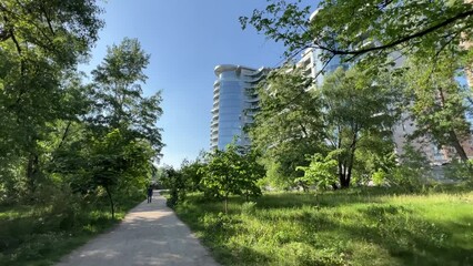 Luxurious modern multi-storey glazed residential complex among a green park