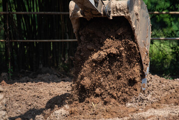 Fototapeta premium Closeup of bulldozer machine digging the ground and removing sand for excavation purpose