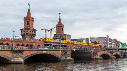 Fototapeta na wymiar Métro de Berlin (U-Bahn) passant sur le célèbre pont Oberbaum (Oberbaumbrücke) en Allemagne