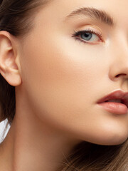 Fototapeta premium Half a beauty portrait with beautiful fashionable nude make-up, extremely long eyelashes. Pink lipstick on the lips. Cosmetology and spa facial skin care