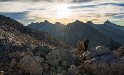 Naklejka premium Male hiker enjoying majestic sunrise in the mountains
